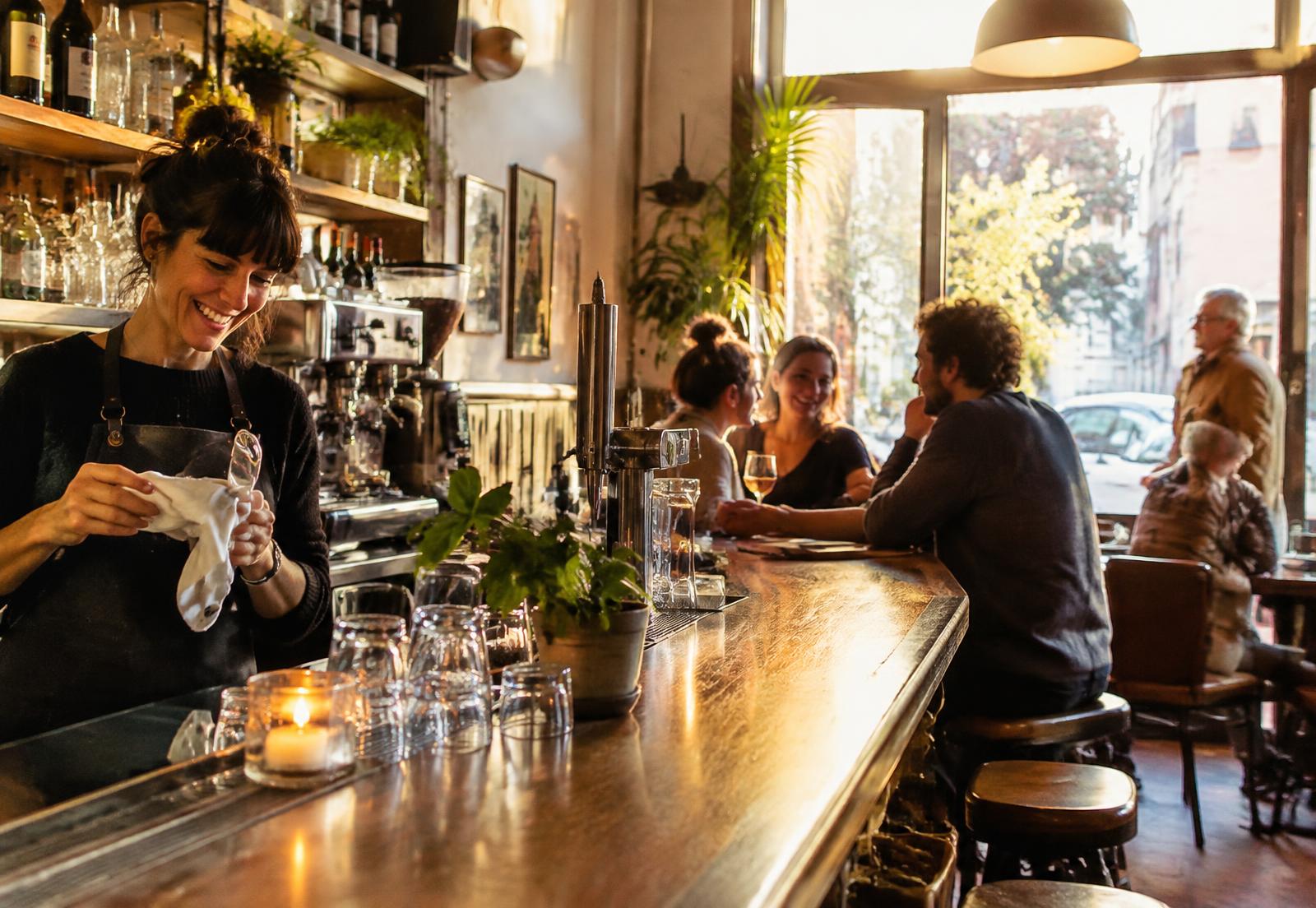 Une gérante derrière le comptoir d’un café de quartier